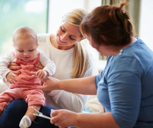 Health Visitor Talking To White Mother With Young Baby